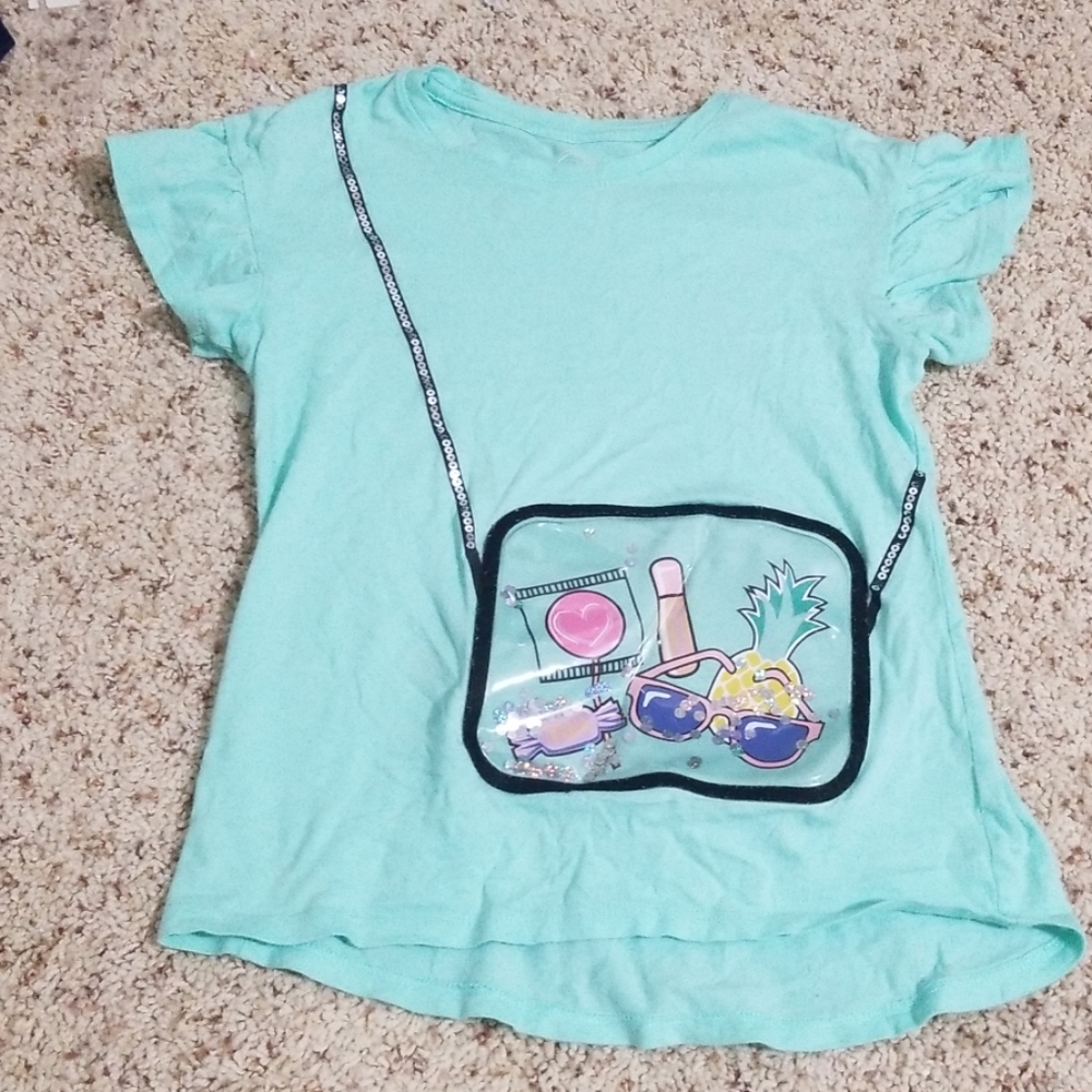 A softly used teal shirt with a fake purse
